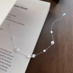 Minimalist S925 sterling silver bracelet featuring matte beads on an open book background