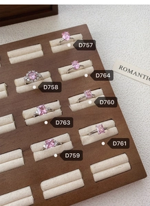 Close-up of pink zircon S925 sterling silver rings displayed on a wooden jewelry tray
