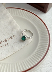 Detailed macro of vintage silver ring with oval emerald gemstone in four-prong setting