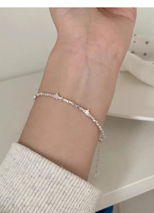 Close-up of S925 sterling silver star charm bracelet on a wrist with adjustable chain link