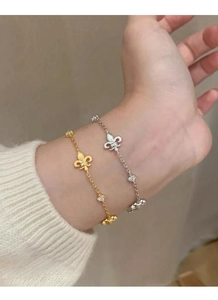 Dettaglio di bracciali in argento e oro con fleur-de-lis e pietre scintillanti