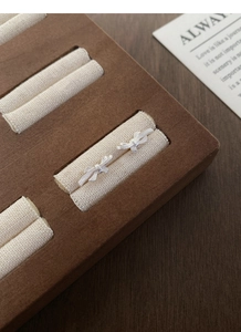 Detail of S999 sterling silver bow earrings featuring a delicate brushed metal texture