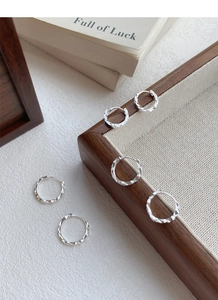 Nahaufnahme von S925 Sterlingsilber Ohrringen mit facettiertem Design auf Holzdekor