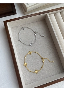 Dettaglio di bracciali a giglio in argento e oro con pietre di zircone in portagioie