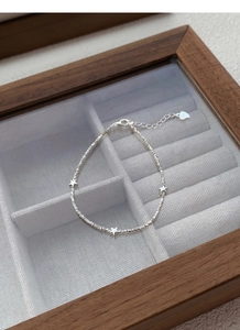Macro shot of S925 sterling silver chain featuring star charms and hallmark engraving