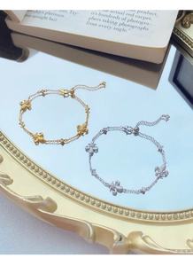 Dettaglio dei bracciali a doppio strato a forma di giglio in oro e argento con chiusura