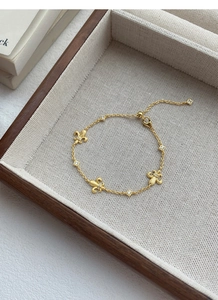 Dettaglio del bracciale in argento S925 dorato con ciondoli giglio e zirconi lucidi