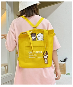 Detail showing yellow canvas tote bag with adjustable straps and cute cartoon bear print