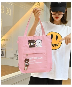 Detailed view of pink canvas tote bag with cartoon bear prints and cute pendant