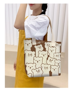 Close-up of brown canvas tote bag with white bear prints and cream webbing handles