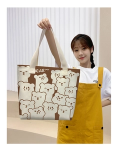 Detail of canvas tote bag with cartoon bear prints and cream webbing handles