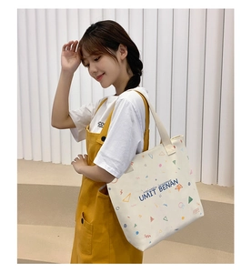 Close-up of canvas tote bag with geometric print and UMIT BENAN lettering detail