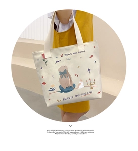 Detail of canvas tote bag featuring artistic cartoon illustrations and Brave and Happy text