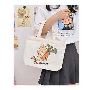 Close-up of cute cartoon rabbit print and The Rabbit text on white canvas handbag