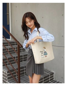 Detail of cream canvas tote bag featuring colorful cartoon girl print and large capacity