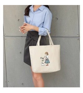 Detailed shot of off-white canvas tote bag featuring happy girl and cat cartoon illustration