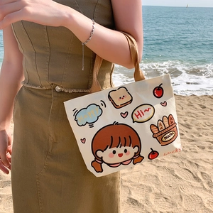 Beige canvas tote bag with cartoon girl illustrations and brown handles in beach setting