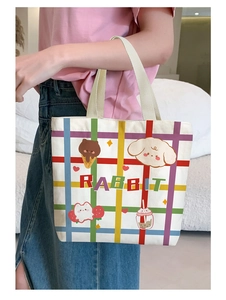 Close-up of white canvas tote featuring colorful cartoon rabbit and animal illustrations