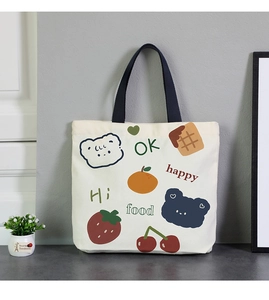 Detail of small canvas lunch bag with cute bear illustrations and blue handles