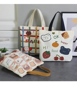 Detailed view of three canvas tote bags with cute cartoon prints and colored handles