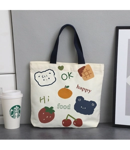 Detail of canvas lunch bag featuring cute cartoon illustrations and blue handles
