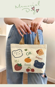 Detailed close-up of a mini canvas tote bag with cute bear and fruit cartoon patterns