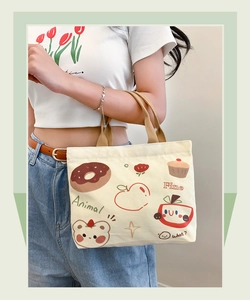 Detail der Canvas Bento Tasche mit bunten Comic Tier Illustrationen und braunen Griffen