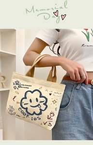 Detail der Segeltuchtasche mit blauem Wolken-Smiley und farbenfrohen Graffiti-Grafikdrucken