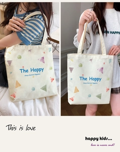 Detail view of casual canvas tote bag with cute planet pattern and cheerful lettering.