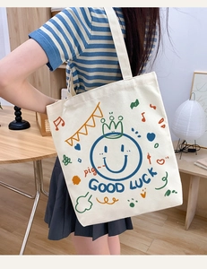 Detailed view of casual canvas tote bag with cute smiley print and shoulder strap.