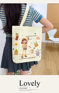 Canvas tote bag detail shot showing cute cartoon print and spacious shoulder strap design.