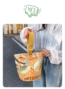 Detailed close-up of orange canvas bucket bag featuring autumn waterbird illustrations