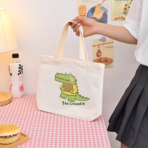 Cute white canvas handbag featuring a green cartoon crocodile and dual handles