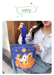 Detail view of the wooden ring handles and cute cat print on this navy canvas bucket bag