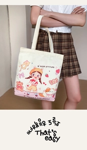 Detailed view of the cute canvas tote bag showcasing cartoon prints and durable shoulder straps.