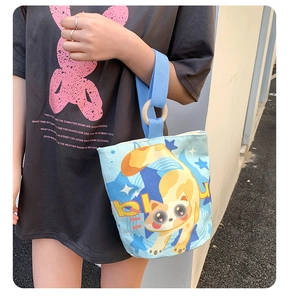 Detailed shot of canvas bucket bag with cat print and wooden ring handle attachment