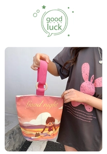 Detail of canvas bucket bag featuring sunset illustration and pink textured strap