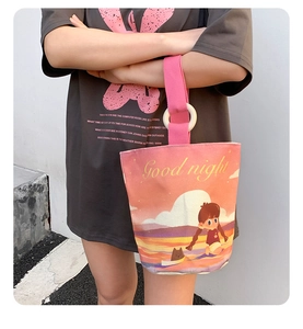 Detail of pink canvas bucket bag with cat illustration and comfortable webbed handle