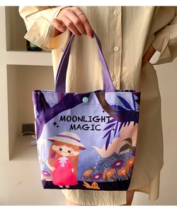 Detail of purple canvas tote bag with cartoon illustration and moonlight magic text