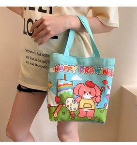 Detail of light blue canvas tote bag showing artistic bear illustration and snap closure