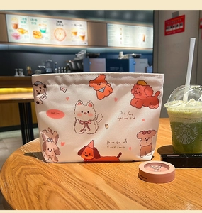 Cute cartoon puppy print on white canvas makeup bag placed on a wooden cafe table