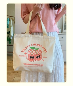 Detail of canvas tote bag featuring cherry heart print and sweet cherry baby text
