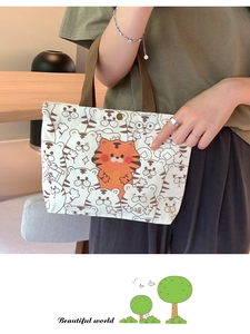 Close-up of a cream canvas tote bag with cute orange tiger prints and snap closure