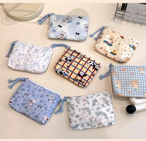 Flat lay of multiple cute cotton mini pouches with diverse cartoon animal patterns and blue zippers