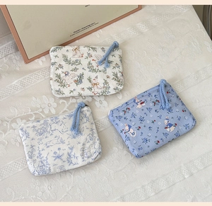 Detailed view of floral and animal print canvas coin purses with zip and woven rope pullers