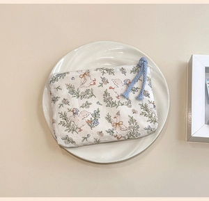 Close-up of mini cotton coin purse with cute duck print and zipper on white plate