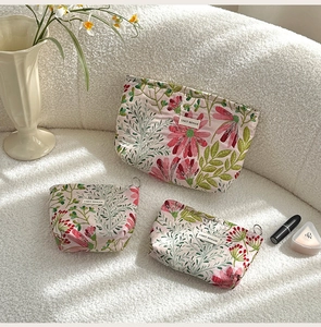 Three-piece floral canvas makeup bag set in small, medium, and large sizes with metal zippers