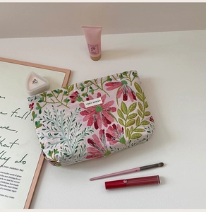 Detailed close-up of pink floral canvas makeup bag with premium skin care essentials