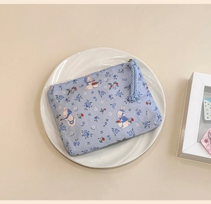 Detailed view of blue floral cotton coin purse with cute rabbit pattern and zipper strap