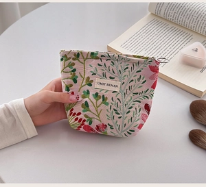 Close-up of floral jacquard fabric texture and zipper detail on canvas makeup pouch